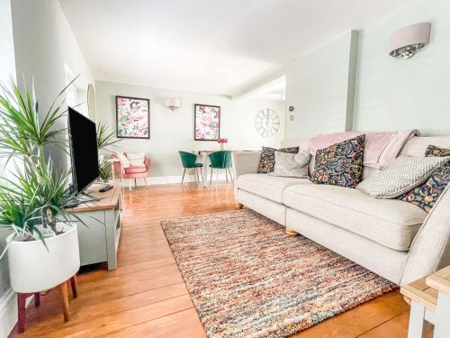 a living room with a couch and a desk with a tv at Beautiful 2 Bedroom Cottage with Private Courtyard in Arundel Centre in Arundel
