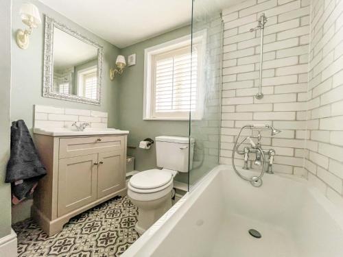 uma casa de banho com uma banheira, um WC e um lavatório. em Beautiful 2 Bedroom Cottage with Private Courtyard in Arundel Centre em Arundel