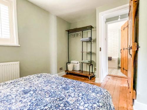 a bedroom with a bed with a blue and white bedspread at Beautiful 2 Bedroom Cottage with Private Courtyard in Arundel Centre in Arundel