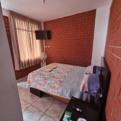 um quarto com uma cama e uma parede de tijolos em Mallorca em Punta Hermosa