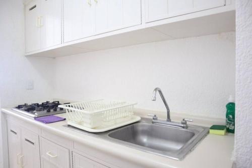 - un évier de cuisine avec un séchoir à vaisselle dans l'établissement Lindo loft en playa Marlin, 2 min de Plaza la Isla - Mar310 -, à Cancún