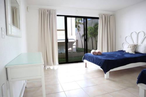 1 dormitorio con cama, mesa y ventana en Lindo loft en playa Marlin, 2 min de Plaza la Isla - Mar310 - en Cancún