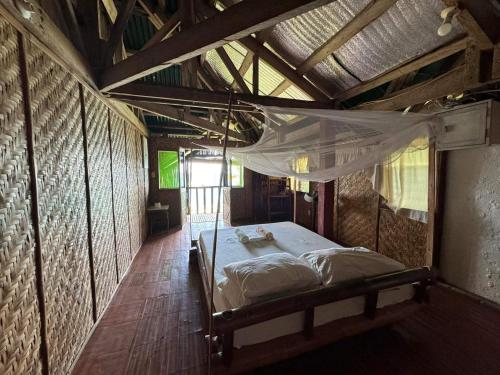 a bedroom with a bed in the middle of a room at Liberty's Lodge and Diving - Apo Island in Dumaguete