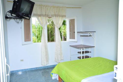 a bedroom with a bed and a tv and a window at HOTEL REAL VILLA ISABELLA in San Agustín