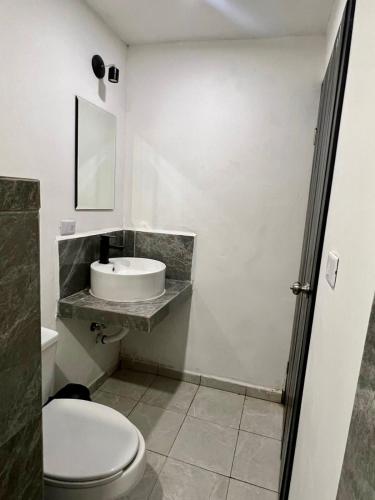 a bathroom with a toilet and a sink at Hotel el capitán tenosique in Tenosique de Pino Suárez