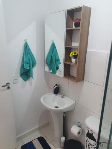 een witte badkamer met een wastafel en een spiegel bij Apto. Campolim a 100mts do shopping Iguatemi in Sorocaba