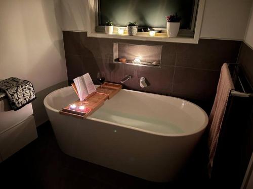 a bathroom with a bath tub with a book on it at Fusion House in Tranmere