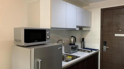 a kitchen with a microwave and a refrigerator at Air Residences in the Heart of Makati City - Great for Tourists, Staycations or Working Professionals in Manila