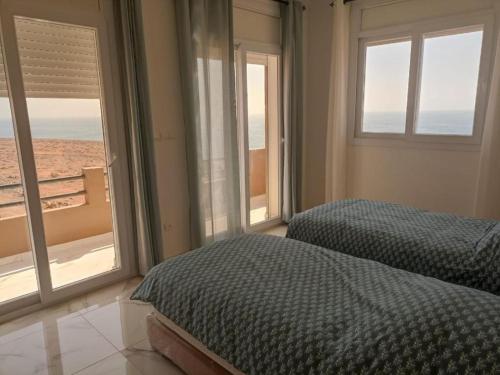 een slaapkamer met 2 bedden en uitzicht op de oceaan bij Mirleft Seaside Horizon in Mirleft