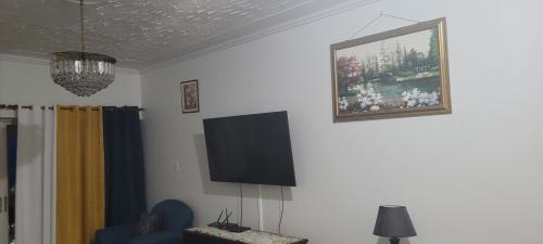 a living room with a flat screen tv on the wall at The Braemar Suite III New Kingston in Kingston