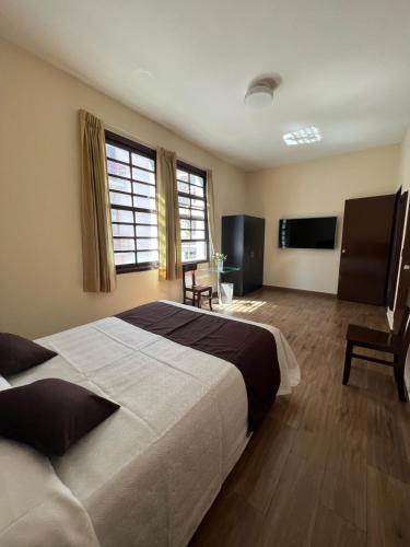 una camera da letto con un letto grande e una televisione di Hotel Tito ad Arequipa