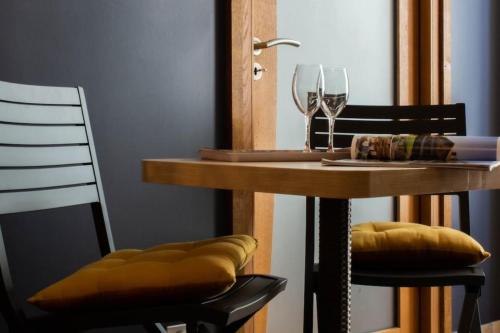 a table with two chairs and a table with wine glasses at Mont Blanc - Emplacement n1 au centre d'Annecy in Annecy