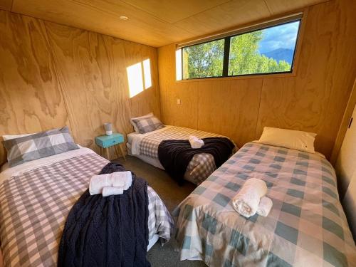 a room with two twin beds and a window at Mill Creek Cottage in Arrowtown