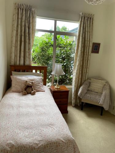 a teddy bear sitting on a bed in a bedroom at Spacious Home in Paraparaumu