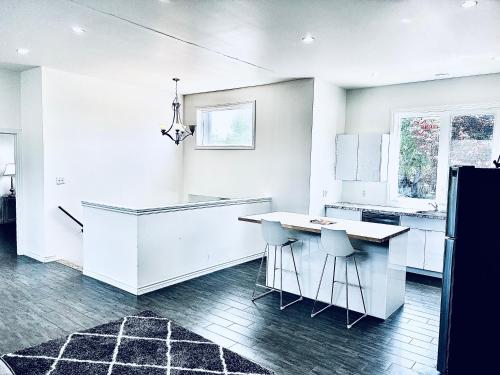 a white kitchen with a counter and stools at LaVida Exclusive Guest House, Free Parking (Rm#2) in London