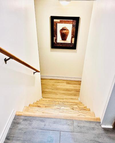a hallway with a staircase with a painting on the wall at LaVida Exclusive Guest House, Free Parking (Rm#2) in London