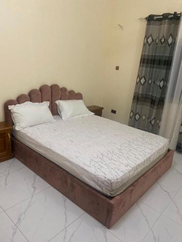 ein Bett mit einem Holzrahmen in einem Schlafzimmer in der Unterkunft Two bedroom apartment Paradise estate Apt in Bureng
