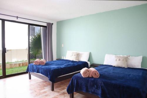 twee bedden in een kamer met een groot raam bij Beach apt, 2 bedrooms, 2 min Plaza la Isla - Mar312 - in Cancun