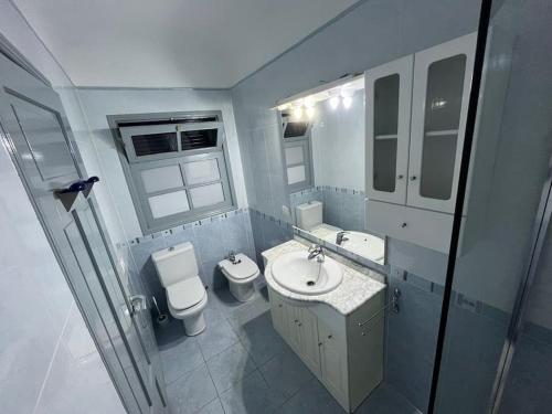 a bathroom with a sink and a toilet and a mirror at Casa marea in Puerto Calero