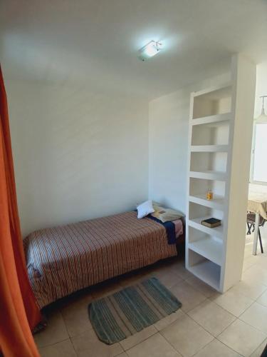 - une chambre avec un lit et une étagère dans l'établissement Depto céntrico, à Junín