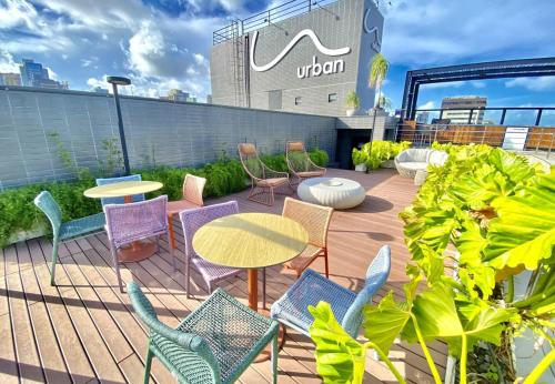 a patio with colorful chairs and tables and a building at URBAN 750 TAMBAU Flat in João Pessoa