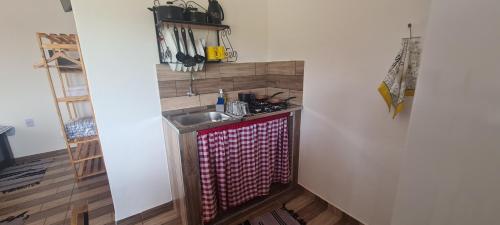 a kitchen with a sink and a counter top at Pousada Colina das Maritacas in São Thomé das Letras