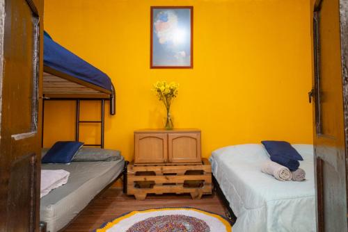 a bedroom with two bunk beds and a yellow wall at Mico Loco Casa Hostal in Bogotá