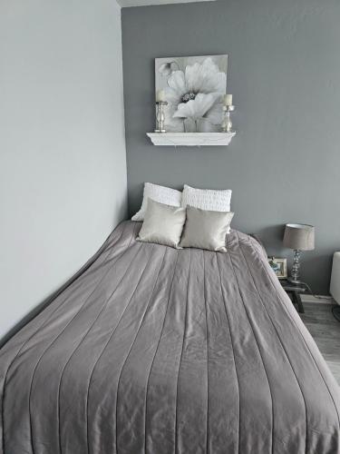 um quarto com uma cama com um edredão cinzento em Kaupunkikoti erinomaisella sijainnilla em Porvoo