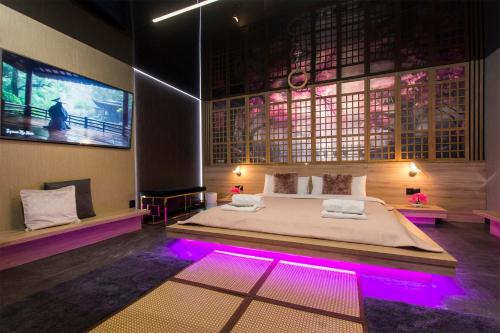 a bedroom with a large bed with purple lights at Grey Aqua Secret Apartament in Gdańsk