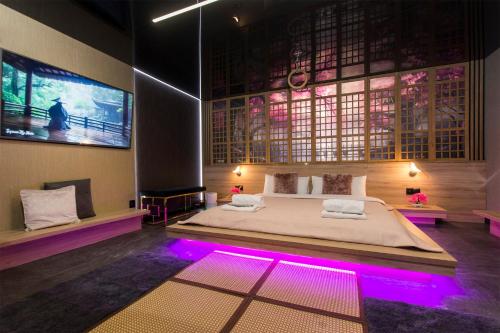 a bedroom with a large bed with purple lights at Grey Aqua SPA by Secret Apartament in Gdańsk