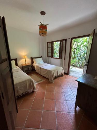 a bedroom with two beds and a window at Vila ORIBA in Santo André