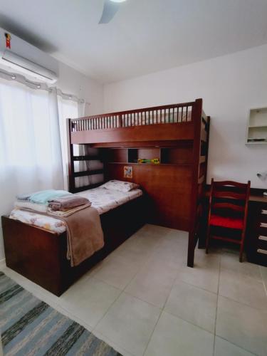 1 dormitorio con 2 literas y silla roja en Casa com piscina privativa, 2 suítes, Sahy., en Mangaratiba