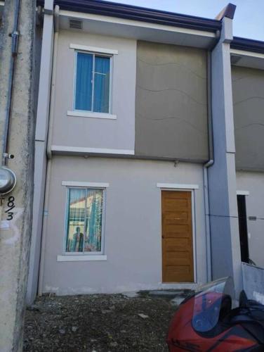 een wit huis met twee ramen en een deur bij Town House Good for Family Stay in General Trias