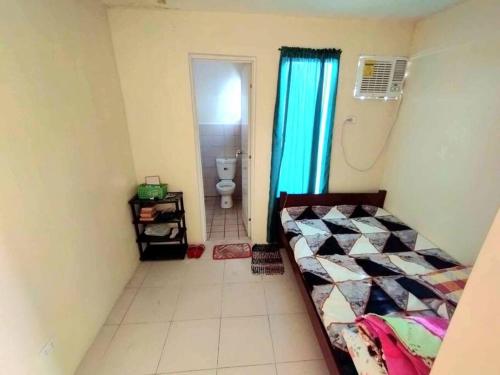 a bedroom with a bed and a bathroom with a toilet at Town House Good for Family Stay in General Trias