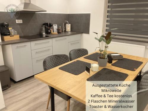a kitchen with a wooden table and chairs in a kitchen at Stierpartment am Pfälzer Wald nähe Outlet Center Zweibrücken in Pirmasens