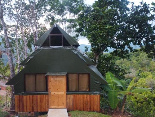 a small green dome house with a door at Finca Makambu in Platanillo