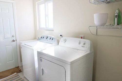 biała pralnia z pralką i suszarką w obiekcie CasaLamar Beachside Retreat w mieście Point