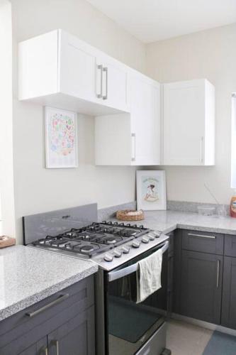 a kitchen with white cabinets and a stove top oven at CasaLamar Beachside Retreat in Point