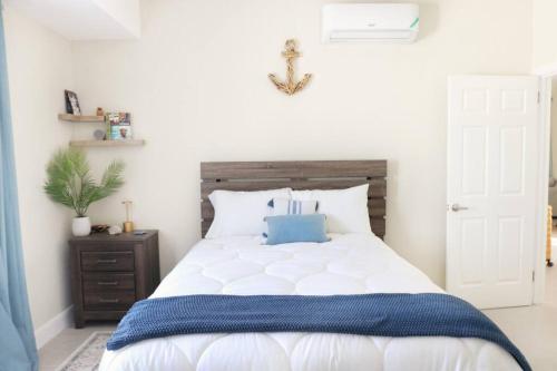 een slaapkamer met een wit bed en een blauwe deken bij CasaLamar Beachside Retreat in Point