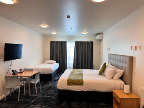 ハミルトンにあるZeta Motelのベッド2台とデスクが備わるホテルルームです。