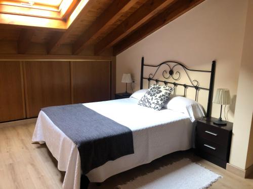 a bedroom with a large bed with a black frame at La plaza in Llanes