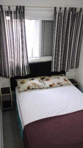 een bed in een slaapkamer met ramen bij Esquina do Sossego in Igaratá