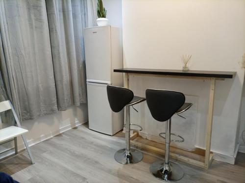 a kitchen with a table and a refrigerator and two chairs at Large 'n' bright House in Middlesbrough