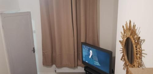 uma televisão sentada numa sala com uma cortina em Large 'n' bright House em Middlesbrough
