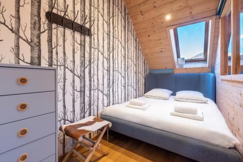 - une petite chambre avec un lit et une fresque murale sur les arbres dans l'établissement Duplex tout confort au centre-ville de Chamonix, à Chamonix-Mont-Blanc