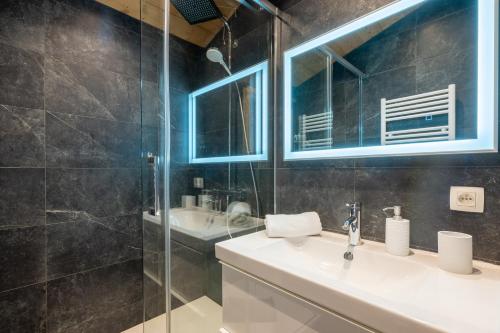 une salle de bain avec un lavabo et une douche en verre dans l'établissement Duplex tout confort au centre-ville de Chamonix, à Chamonix-Mont-Blanc