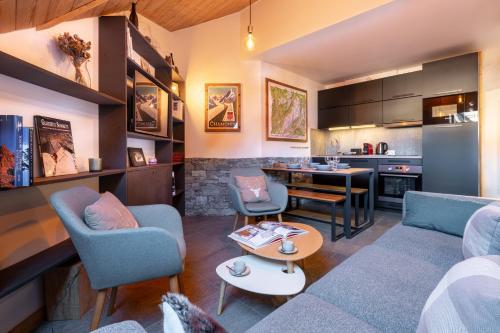 un salon avec un canapé et des chaises et une cuisine dans l'établissement Duplex tout confort au centre-ville de Chamonix, à Chamonix-Mont-Blanc