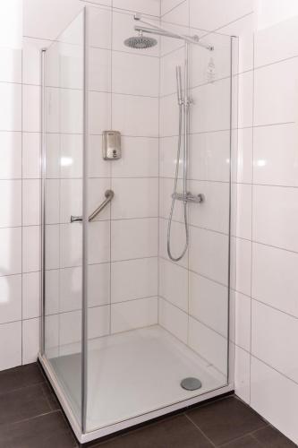 a shower with a glass door in a bathroom at Smile Apartment - barrierefrei in Tiddische