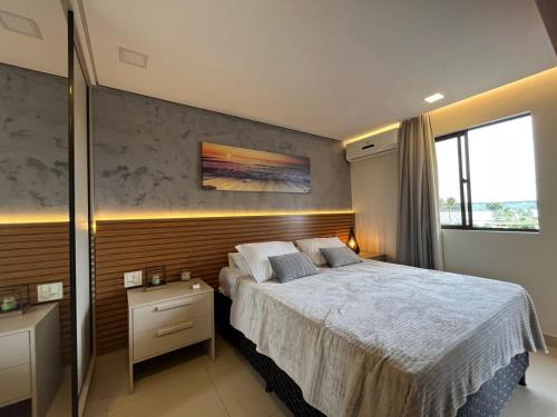 a bedroom with a large bed and a large window at Lake Side Reformado Lago Paranoá Brasília DF in Brasília