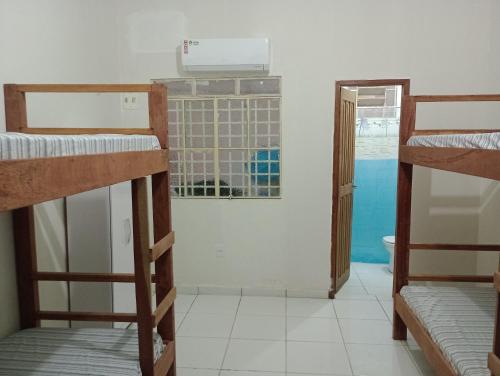 a room with three bunk beds and a bathroom at AM-RR Hostel in Manaus